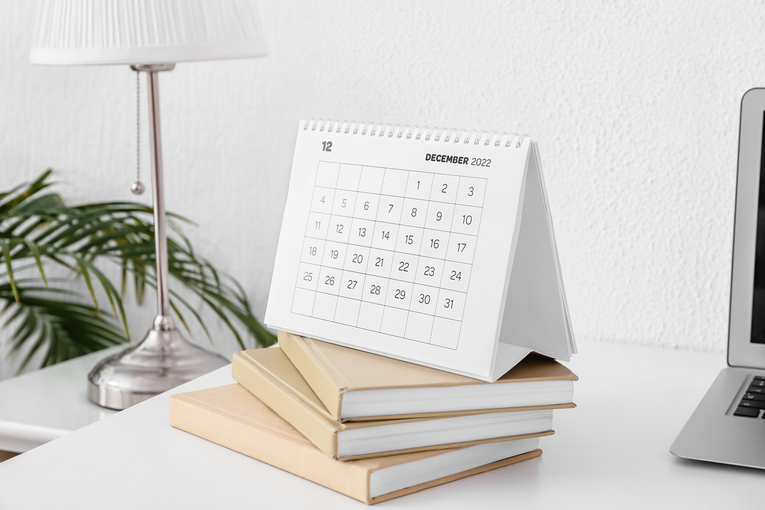 Paper Calendar for December 2022 with Books at Workplace